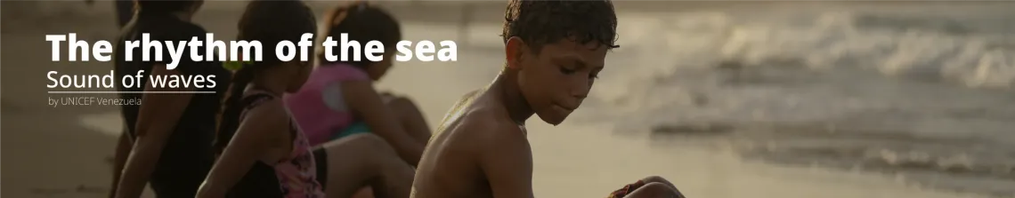 Ni&ntilde;o mirando hacia abajo en la playa, con arena y mar de fondo.