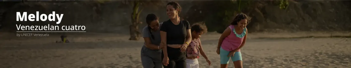 Tres personas r&iacute;en y caminan juntas por la playa al atardecer.
