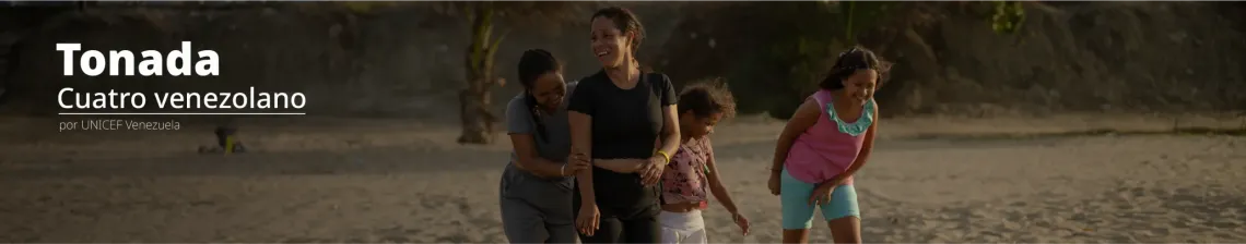 Familia r&iacute;e mientras caminan por la playa al atardecer.