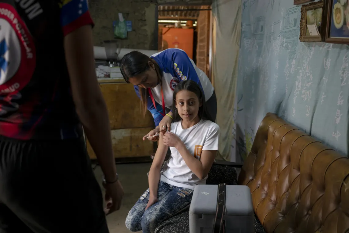 Yoselin Blanco, coordinadora del Programa Ampliado de Inmunizaci&oacute;n de la ASIC 506, vacuna a Yuleidy Fabiola durante la visita de la brigada de salud a su casa. 