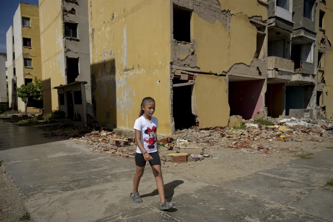 Derwimar, de 9 a&ntilde;os, camina frente a los edificios de Mare Abajo donde viv&iacute;a antes de los terremotos. 