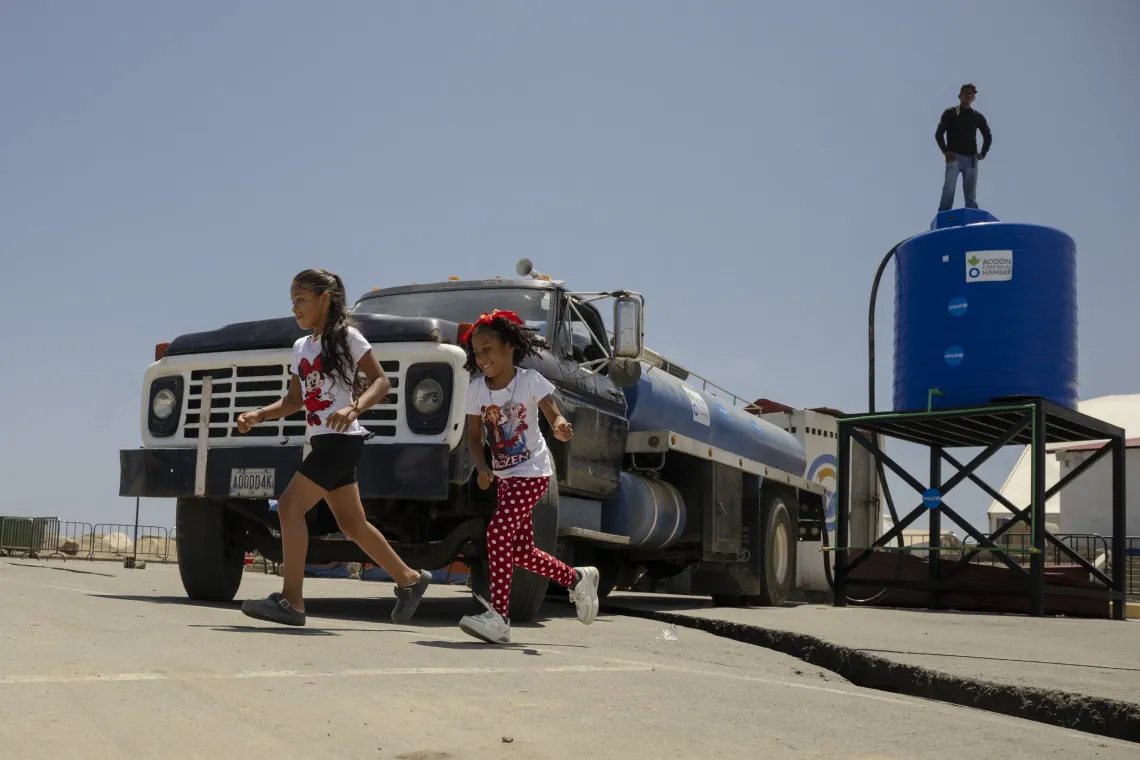 Derwimar y Ana Milena corren para avisar a su familia de que lleg&oacute; el cami&oacute;n cisterna. UNICEF apoya el acceso a agua segura junto a su socio, Acci&oacute;n contra el Hambre, las autoridades y la comunidad. 