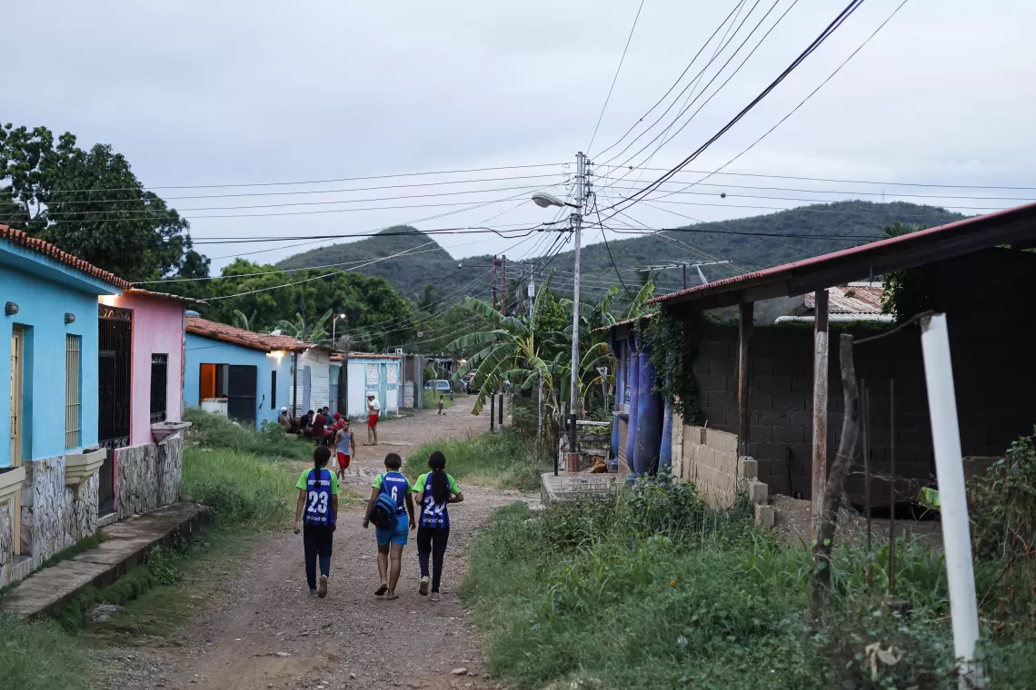 Un grupo de adolescentes integrantes de la academia Misercordia F.C. caminan por las calles despu&eacute;s de terminar una pr&aacute;ctica de futbol.