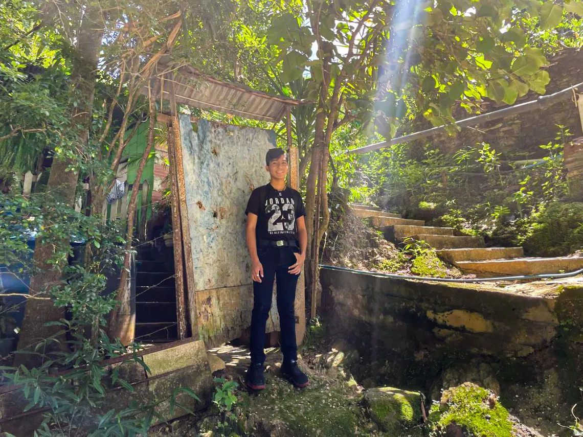 Luis Gonz&aacute;lez (15 a&ntilde;os), sonr&iacute;e a la c&aacute;mara en la puerta de su casa en Las Tejer&iacute;as, estado Aragua, Venezuela, el 13 de julio de 2023.  