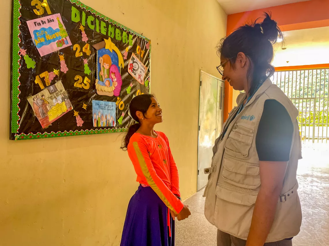 Valennis Terrero talks with Yareidy Rivas, Social and Behavior Change Specialist, in the hallway of a school in Las Tejer&iacute;as.