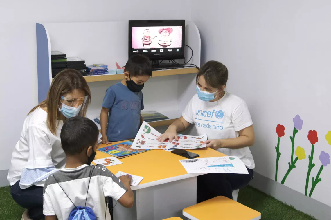 Alejandra Pocaterra, Oficial de Comunicaciones de UNICEF, conversando con Yeiker, 7, (izquierda) y Gabriel, 4, (derecha) en un &aacute;rea de juegos rehabilitada por UNICEF en uno de los Consejos de Protecci&oacute;n apoyados por UNICEF, en Caracas.