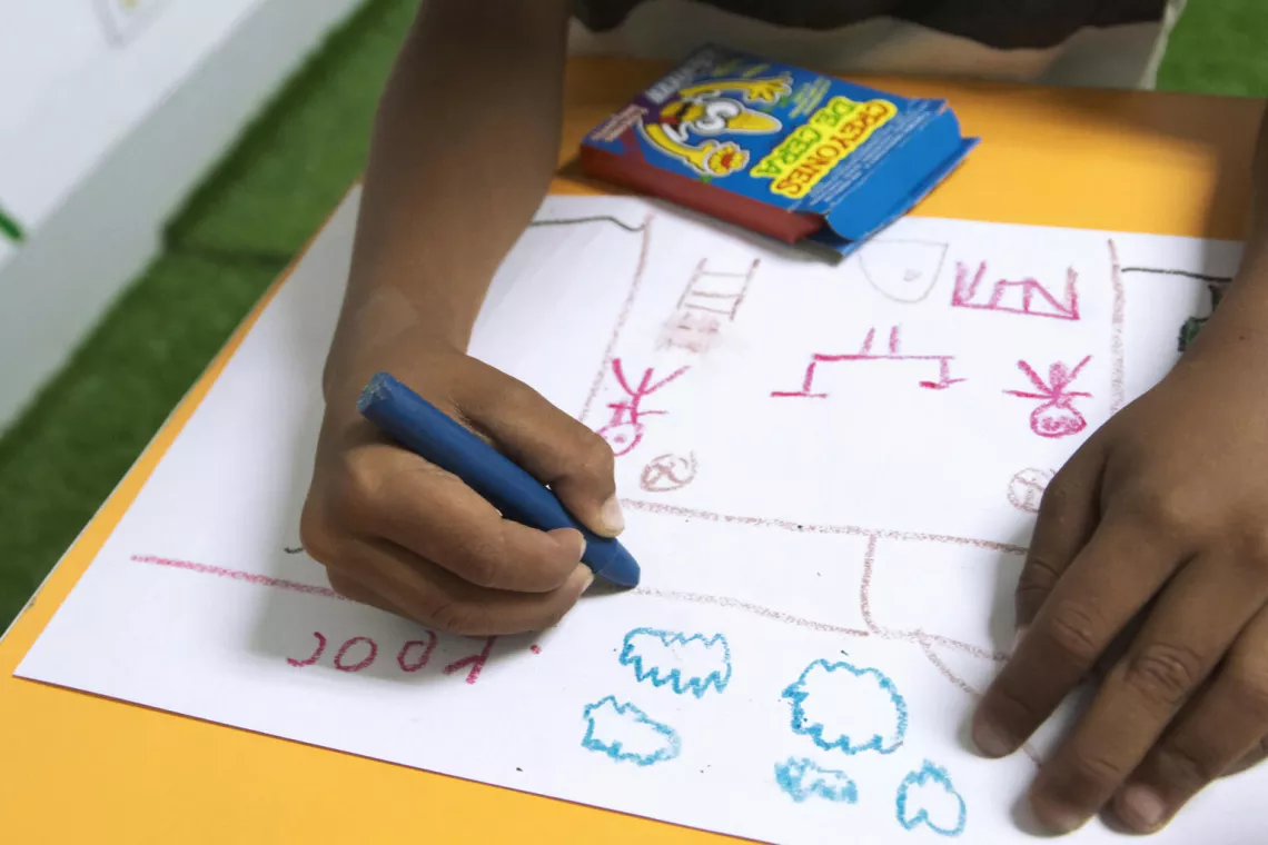 Yeiker, de 7 a&ntilde;os, dibuja en un &aacute;rea de juegos rehabilitada por UNICEF en uno de los Consejos de Protecci&oacute;n apoyados por UNICEF, en Caracas.