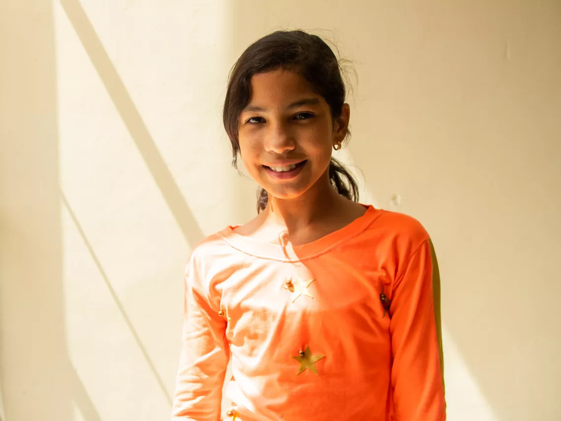 Valennis Terrero, an 11-year-old girl who lived through the Las Tejer&iacute;as landslide, smiles for the camera in the hallway of her school days after the landslide.