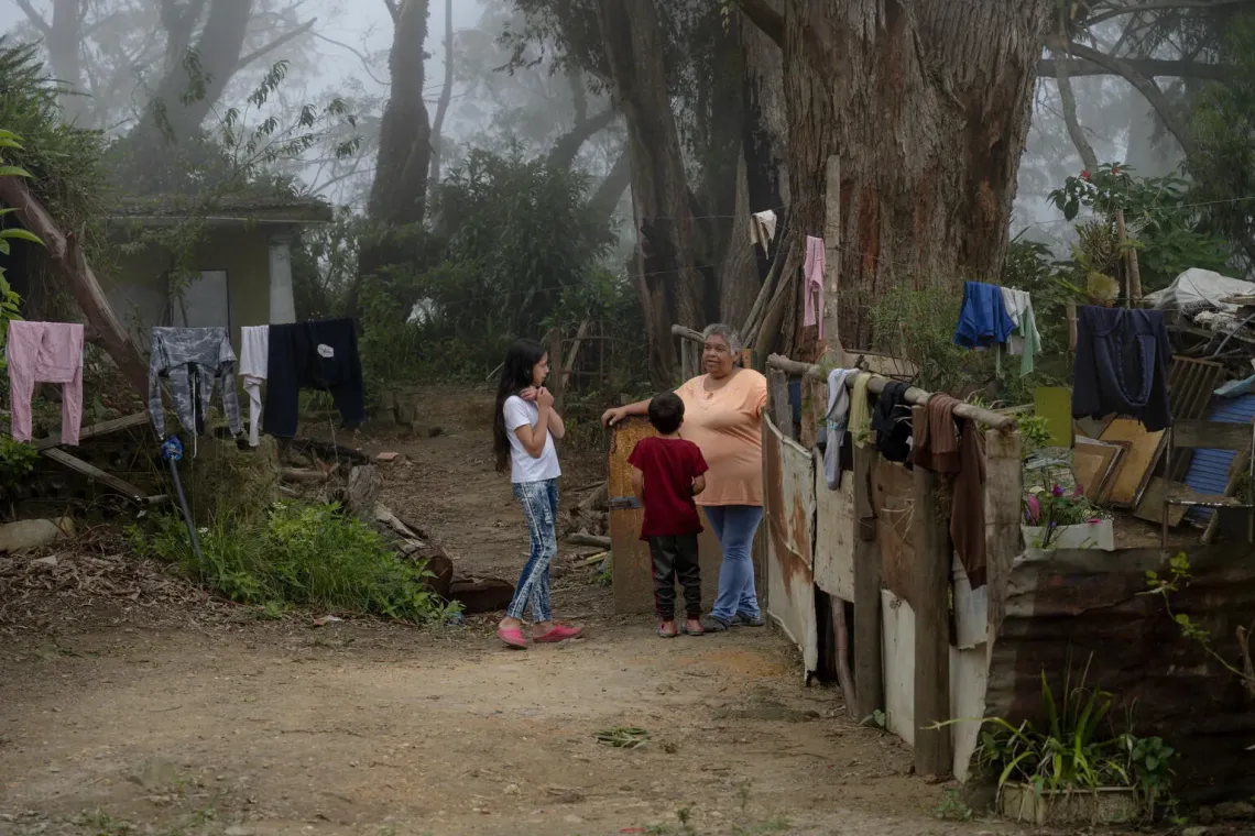 Yuleidy Fabiola conversa con su hermano y su abuela en el exterior de la vivienda familiar. 