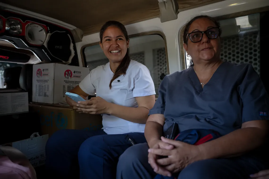 Francisca Guilarte (left), the outreach session coordinator, and a fellow health team member sit inside a vehicle during a UNICEF-supported health outreach session in Santa Luc&iacute;a del Tuy, Miranda State, Venezuela.