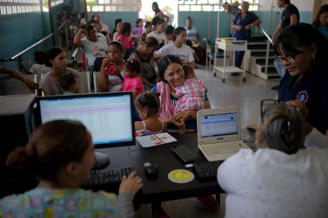 Families wait and consult with health workers during a UNICEF-supported health outreach session in Santa Luc&iacute;a del Tuy, Miranda State, Venezuela.