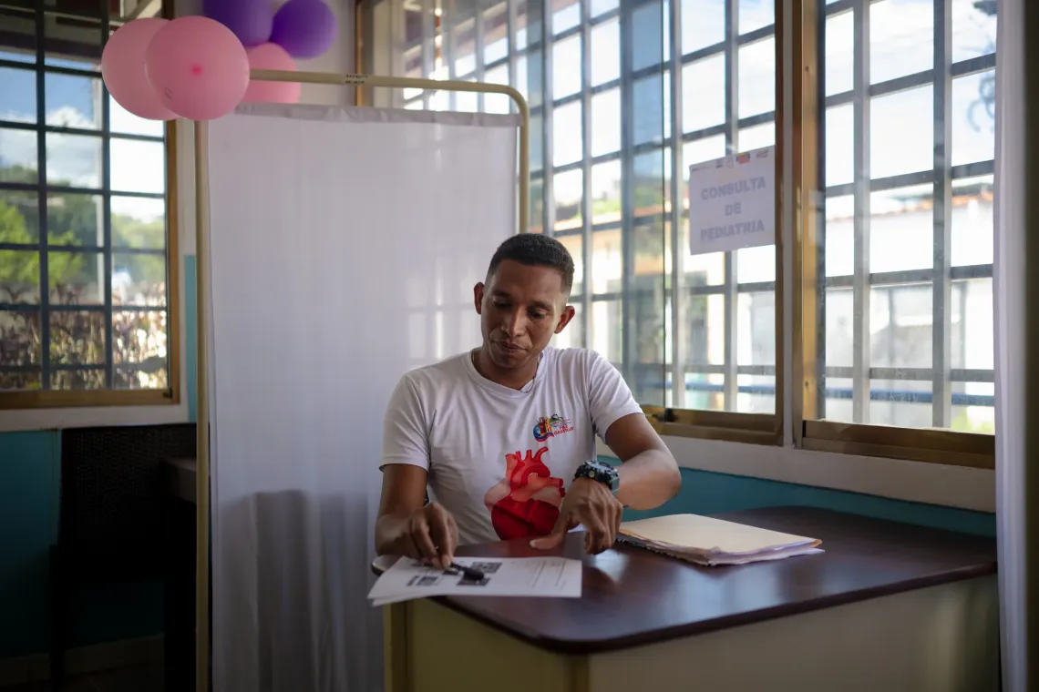 Mois&eacute;s Sanabria, a community health worker with the Basic Health Teams, sits at a desk during a UNICEF-supported health outreach session in Santa Luc&iacute;a del Tuy, Miranda State, Venezuela.