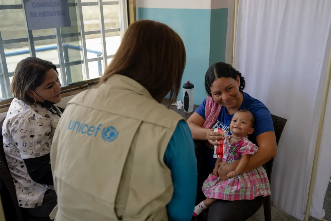Zulay Gonz&aacute;lez, Nutrition Officer at UNICEF Venezuela, speaks with Anderbis Acosta as she holds her nine-month-old daughter during a UNICEF-supported health outreach session in Santa Luc&iacute;a del Tuy, Miranda State, Venezuela.