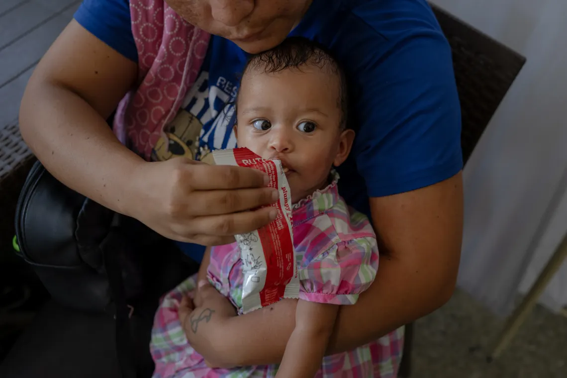 Anderbis Acosta feeds ready-to-use therapeutic food (RUTF) to her nine-month-old daughter during a UNICEF-supported health outreach session in Santa Luc&iacute;a del Tuy, Miranda State, Venezuela.