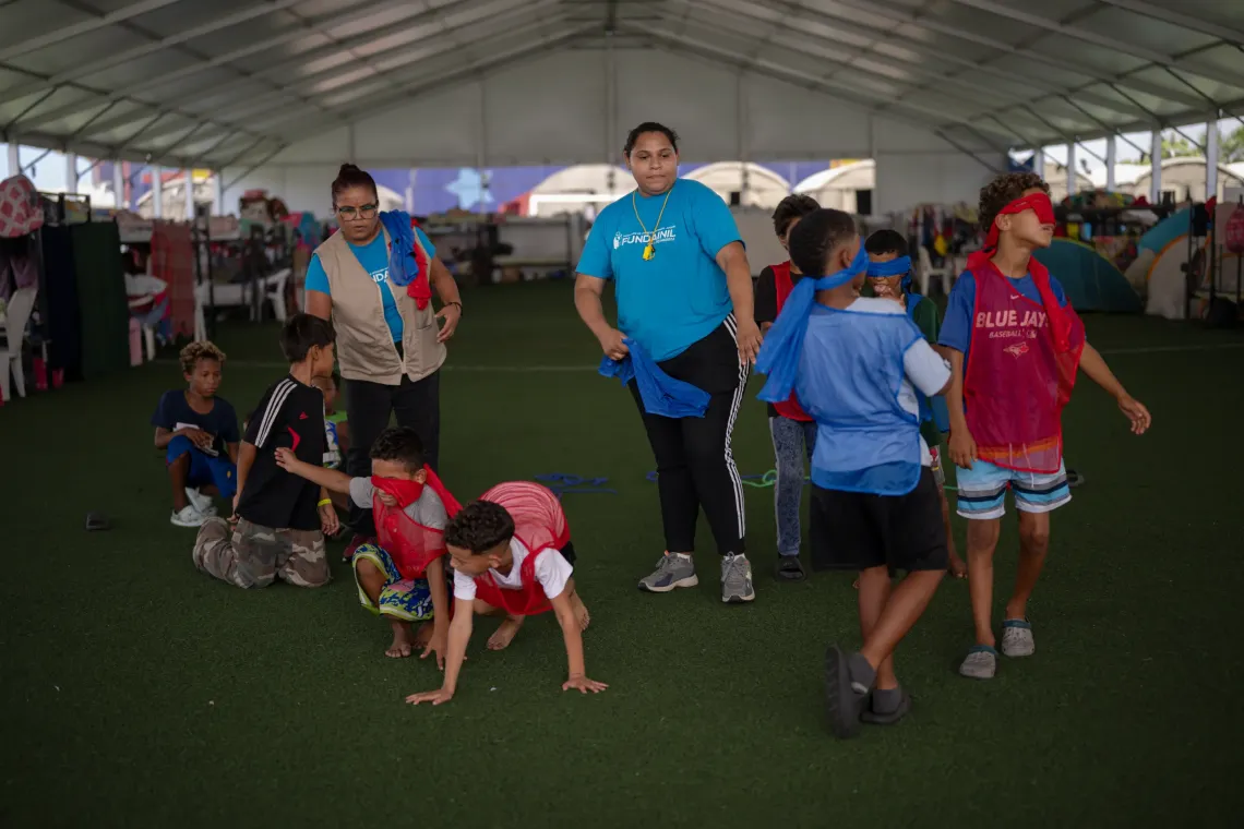Aracely David, from Fundainil, joins Dami&aacute;n and other children during a UNICEF-supported play activity at the temporary camp in the Jos&eacute; Mar&iacute;a Vargas sports complex in La Guaira.