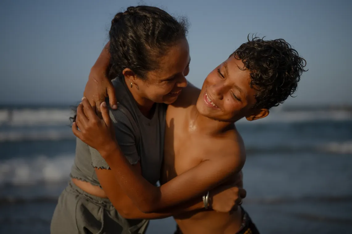 Dami&aacute;n, 13, hugs his aunt Mercedes on a beach in La Guaira, Venezuela. She took him into her care after his mother died in the June earthquakes.