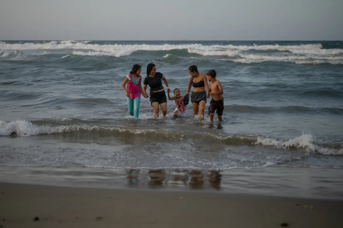 Dami&aacute;n, de 13 a&ntilde;os, su t&iacute;a Mercedes y su familia comparten un abrazo a orillas del mar en La Guaira, Venezuela.