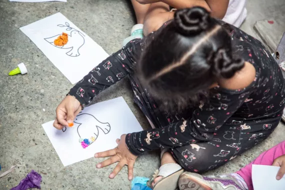 Una ni&ntilde;a dibuja sobre una hoja de papel blanco.