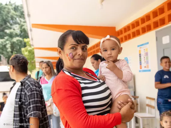 Yelitza Griman, school teacher, is holding her nephew.