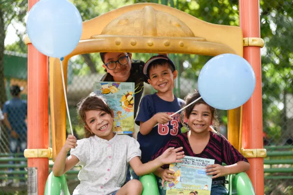 En la imagen se ven unos ni&ntilde;os sonriendo, con globos de UNICEF.