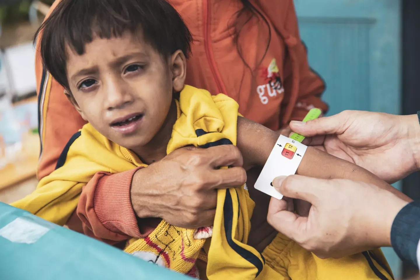 A doctor conducts a malnutrition assessment on a boy