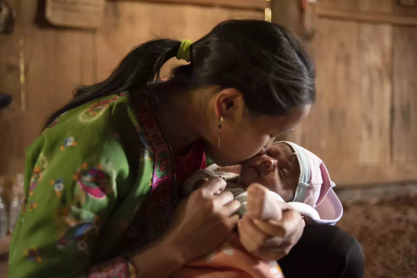 A mother cuddles an infant