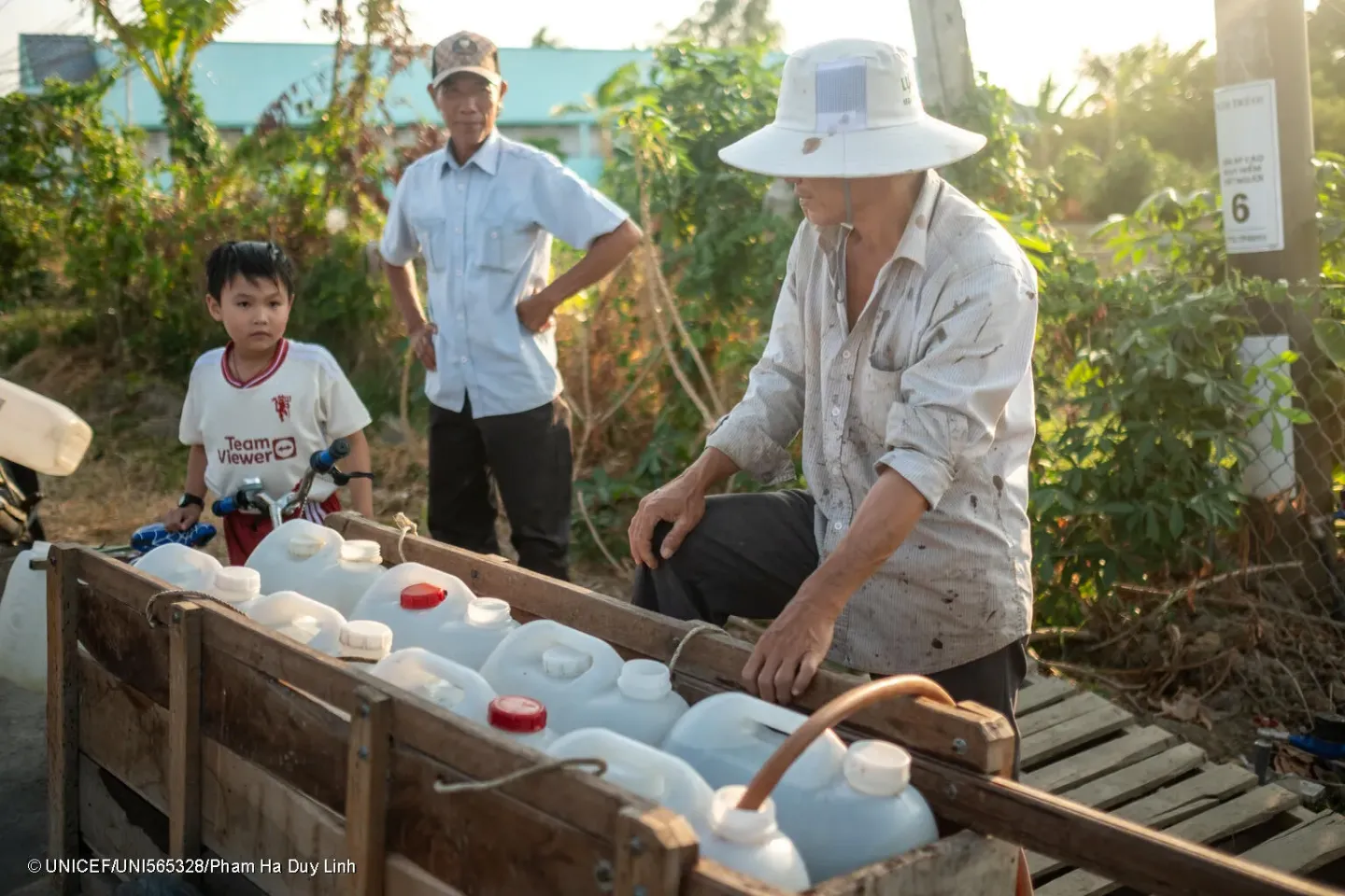 Huynh Trong Khang, 10, carries bottles of fresh water delivered by sponsors from nearby provinces in Tan Phuoc Commune, Go Cong City, Tien Giang Province, Viet Nam, on Monday, April 22, 2024. 