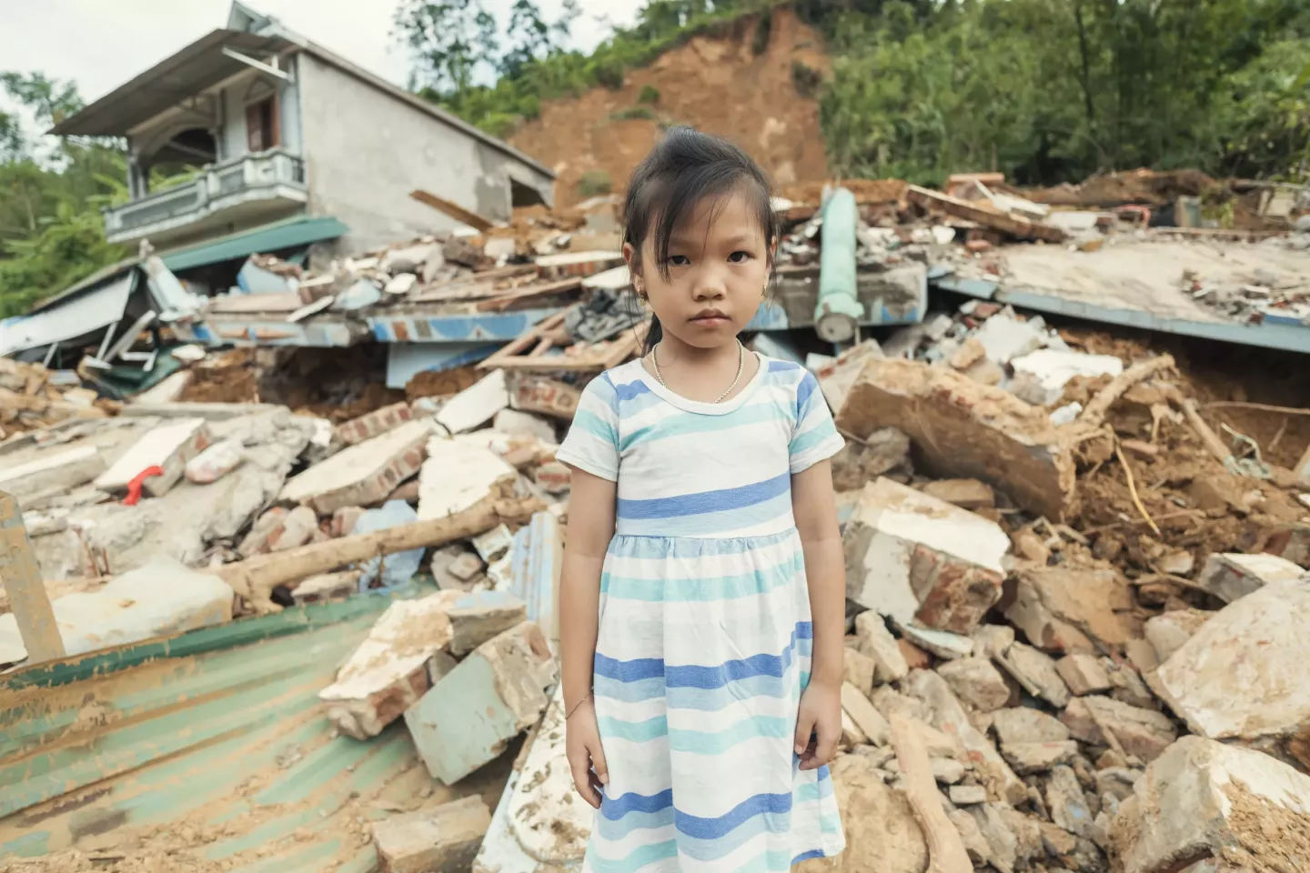 Cao Huyền Trang (6) stands in front of her home, destroyed by a landslide caused by Super Typhoon Yagi&rsquo;s heavy rains.