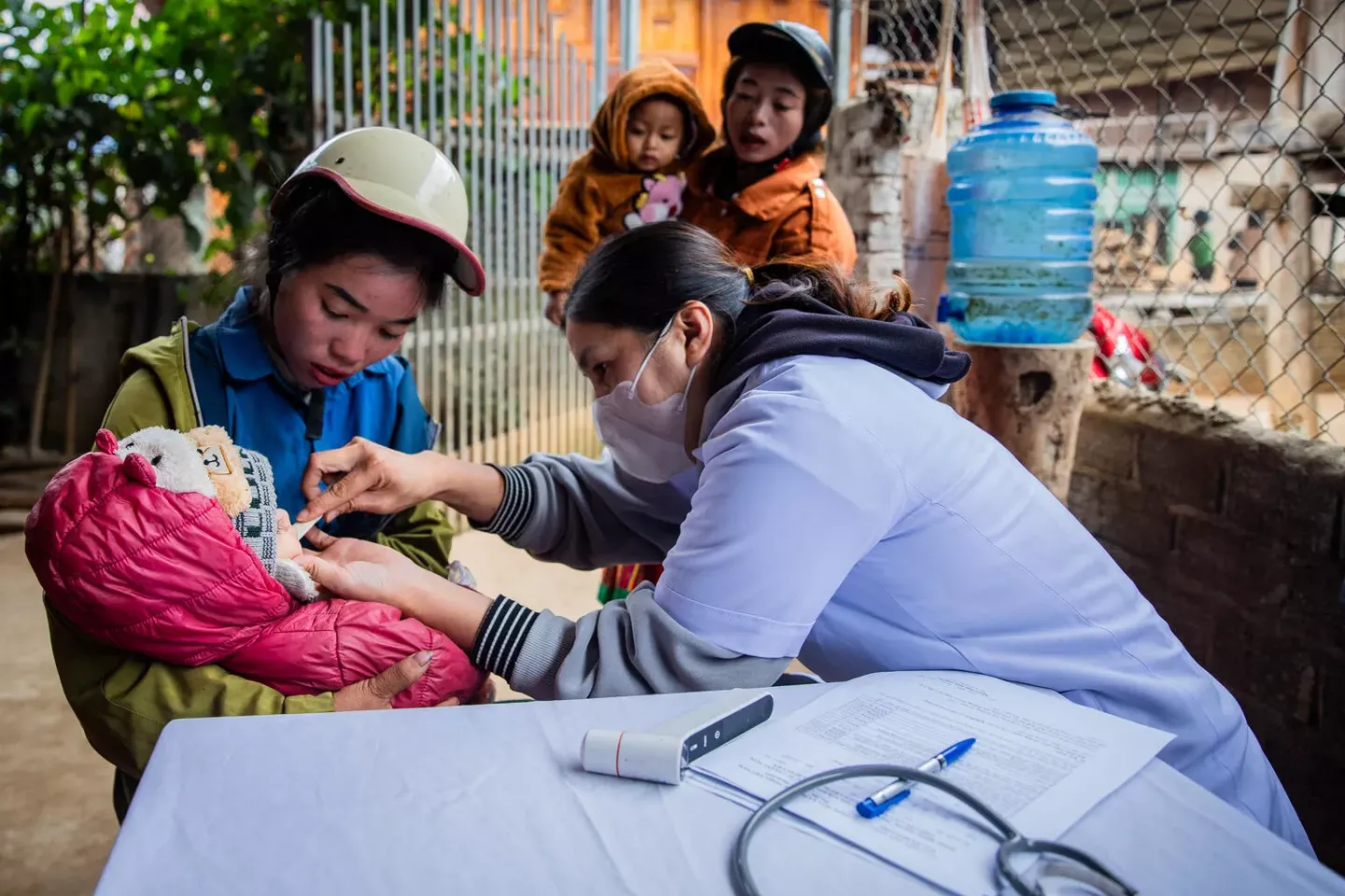 Truong Thi Lan Anh, Deputy Head of Keo Lom Commune Health Centre, conducts a screening examination for Lo Minh Tuan Ut, a 2-year-old child, during a mobile vaccination session in Suoi Lu Hamlet, Keo Lom Commune, Dien Bien Dong District, Dien Bien Province.