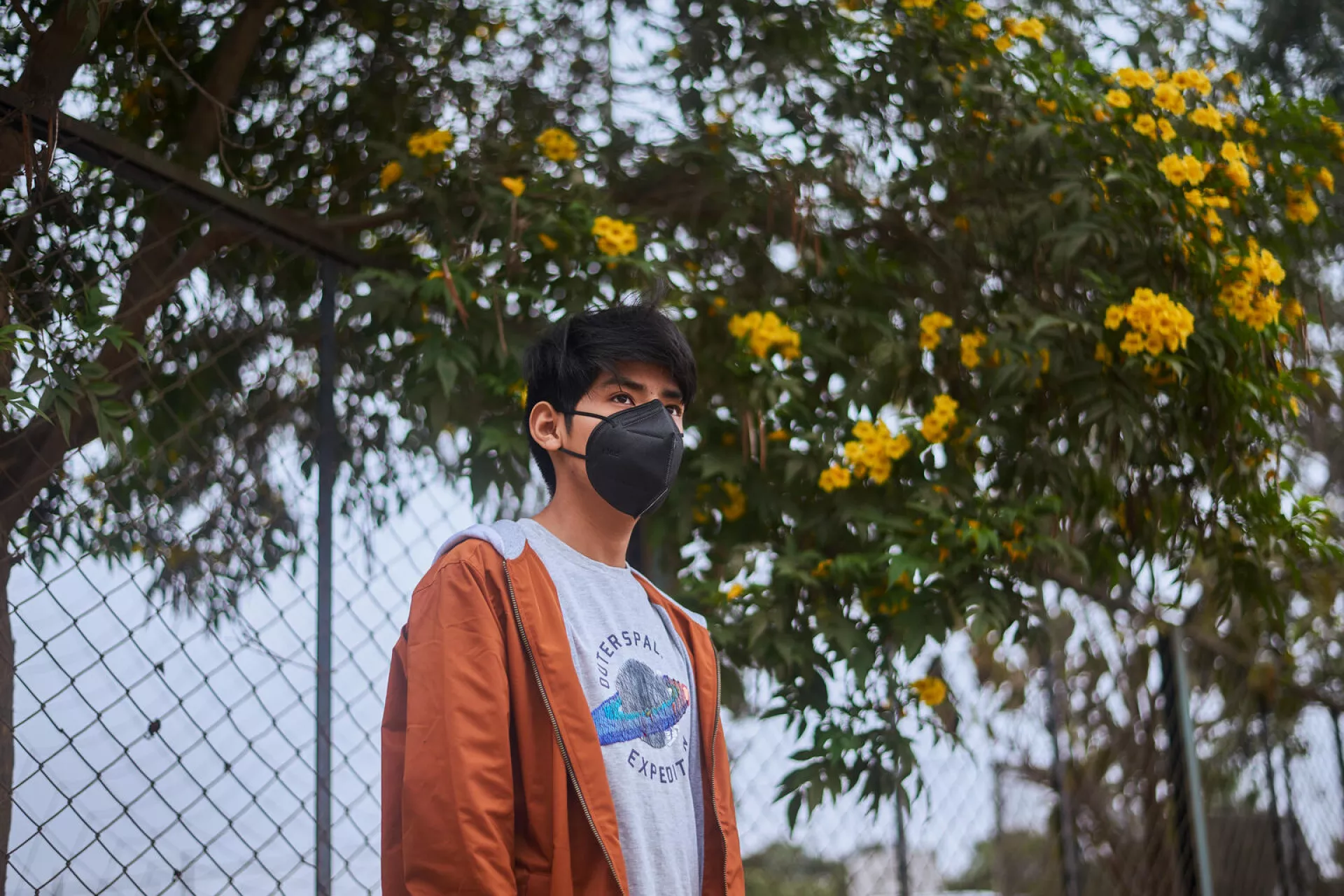 Andre [NAME CHANGED], 14, stands in the grounds of a repurposed sports stadium in Carabayllo, a district in the north of Lima, Peru, while he waits for the time of his scheduled appointment to be seen at the Community Mental Health Centre that now occupies a building there.