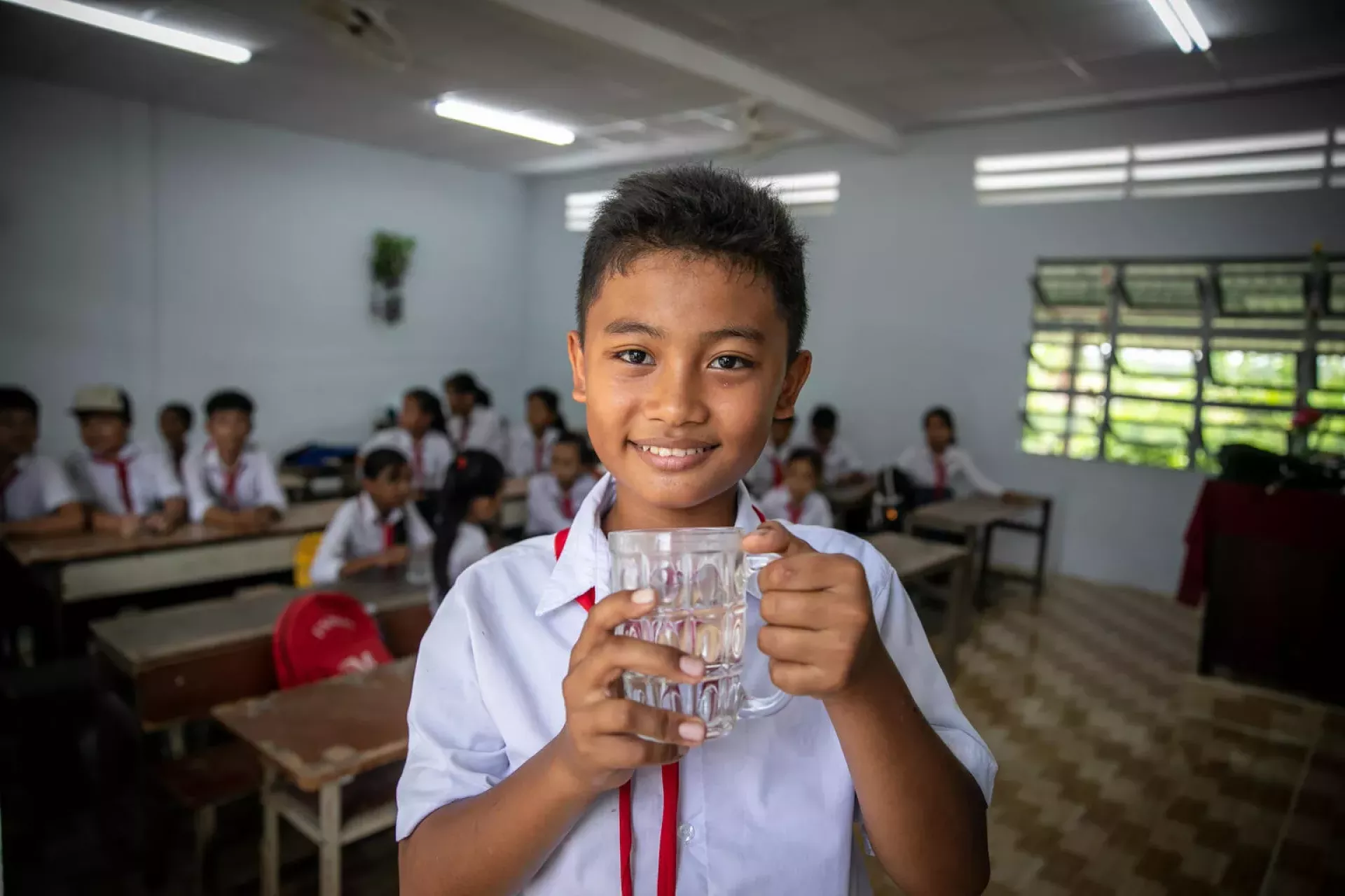 Em b&eacute; trai uống nước trong lớp