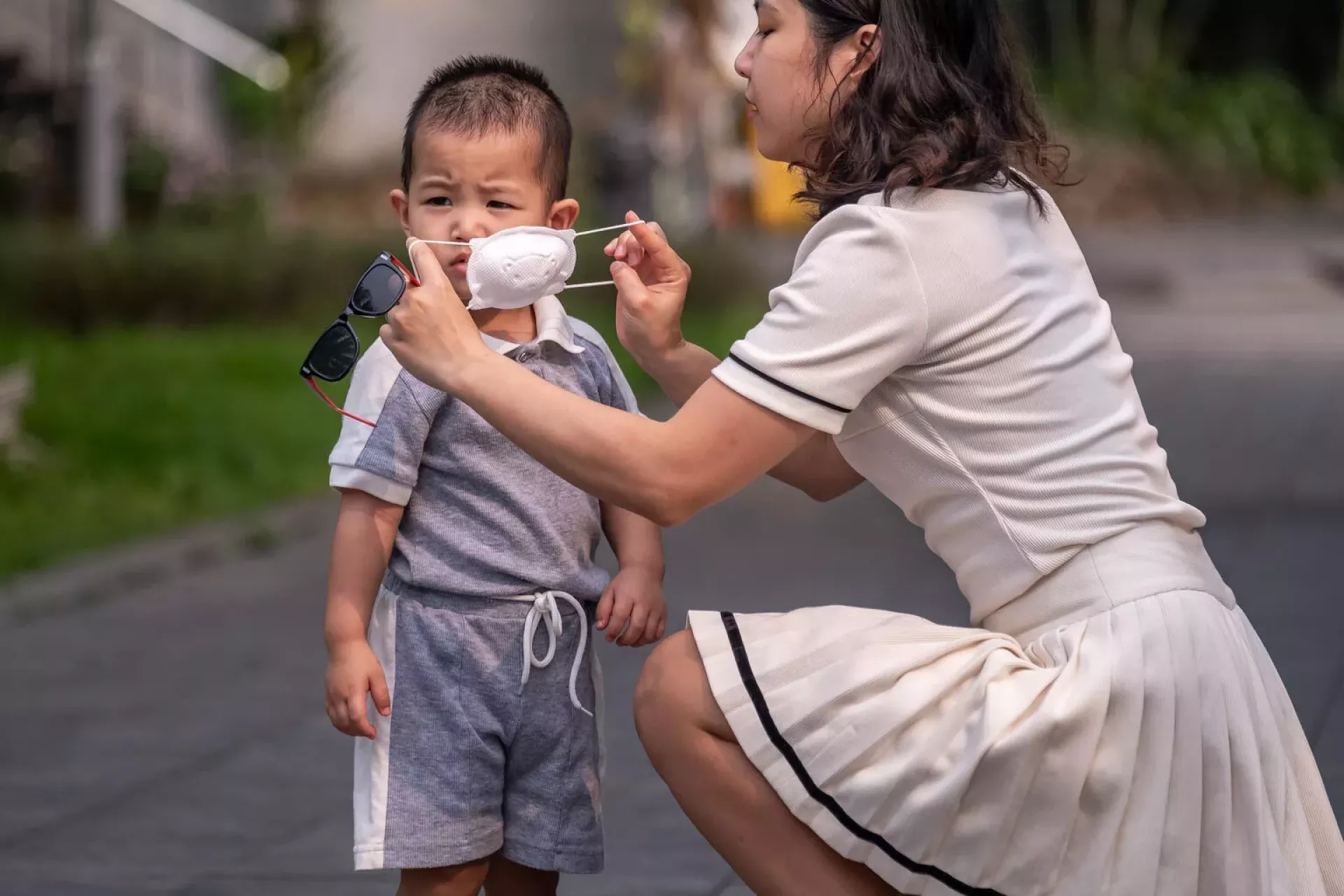 Hà Nội ô nhiễm không khí trầm trọng đầu tháng 12/2025 — người dân nên lưu tâm sức khỏe hô hấp 4 Mother puts on an air mask for her child
