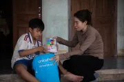 Lan helps Khoi pack his new crayons into a UNICEF backpack, which was distributed to impacted families as part of the post-typhoon emergency response.