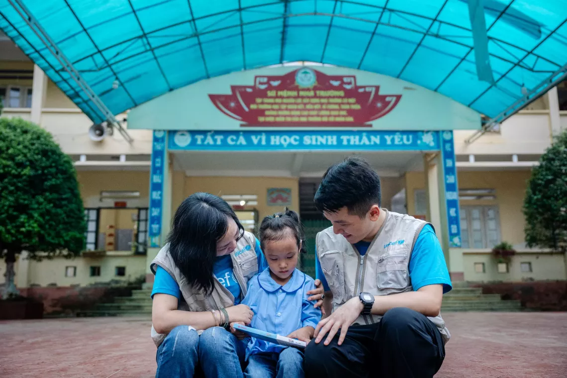 Hoang Ngoc Lan sits with UNICEF staff.