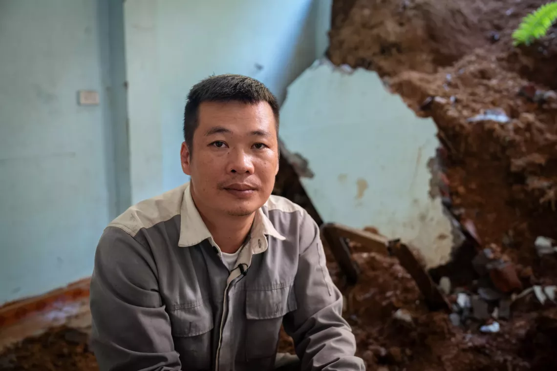 Anh L&ugrave; Văn Tu&acirc;n, trưởng th&ocirc;n M&uacute;c, tỉnh L&agrave;o Cai, ngồi trước đống đổ n&aacute;t do sạt lở đất g&acirc;y ra khiến một bức tường trong nh&agrave; anh bị sập.