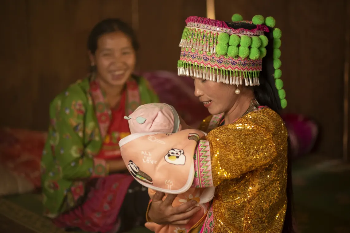 Ethnic midwife Sung Thi Cua (with the baby) during a maternal and newborn health check up with Sung Thi Ghenh, mother of Hang A Cua at their house in Pu Nhi commune, located in northern Dien Bien province&rsquo;s Dong district
