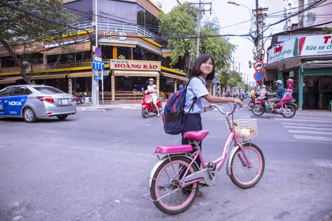 A girl walks her bicycle