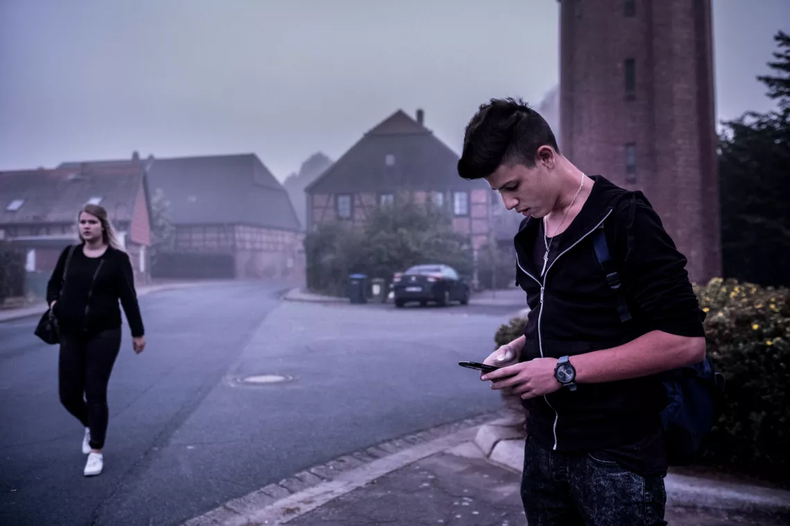 Ahmad Abdul-Halim, 16, uses his mobile phone as he leaves the youth residence for school in Peine, Germany