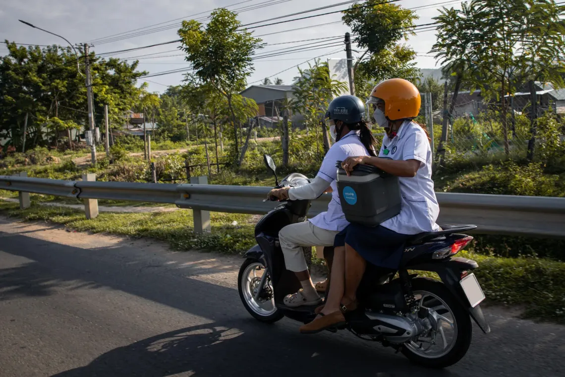 H&rsquo;Liu (ngồi ph&iacute;a sau) v&agrave; đồng nghiệp đi xe m&aacute;y đến b&ocirc;n Chư Gu để tổ chức một buổi ti&ecirc;m chủng ngoại trạm.