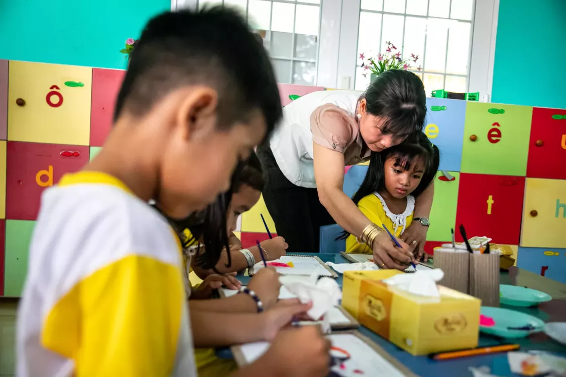 C&ocirc; gi&aacute;o đang chỉ cho một bạn học sinh nữ c&aacute;ch vẽ
