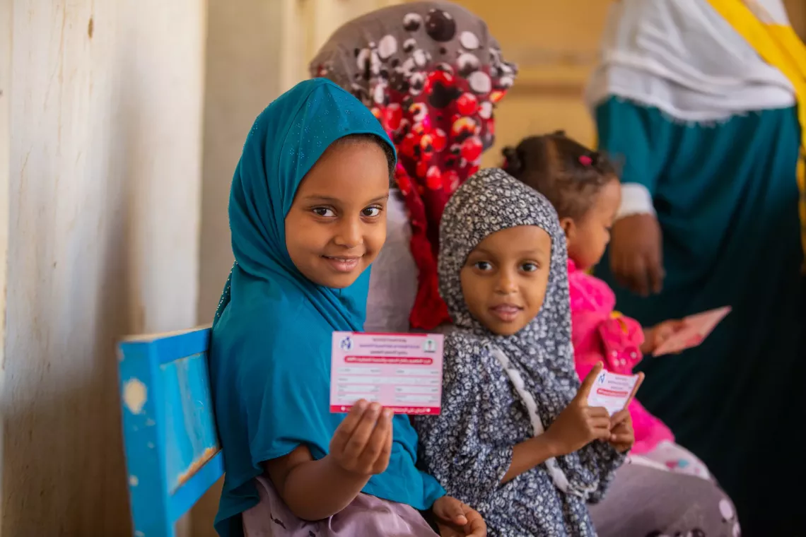 A young girl flashes her vaccination card after she was vaccinated against measles and rubella in Kassala state, Sudan.