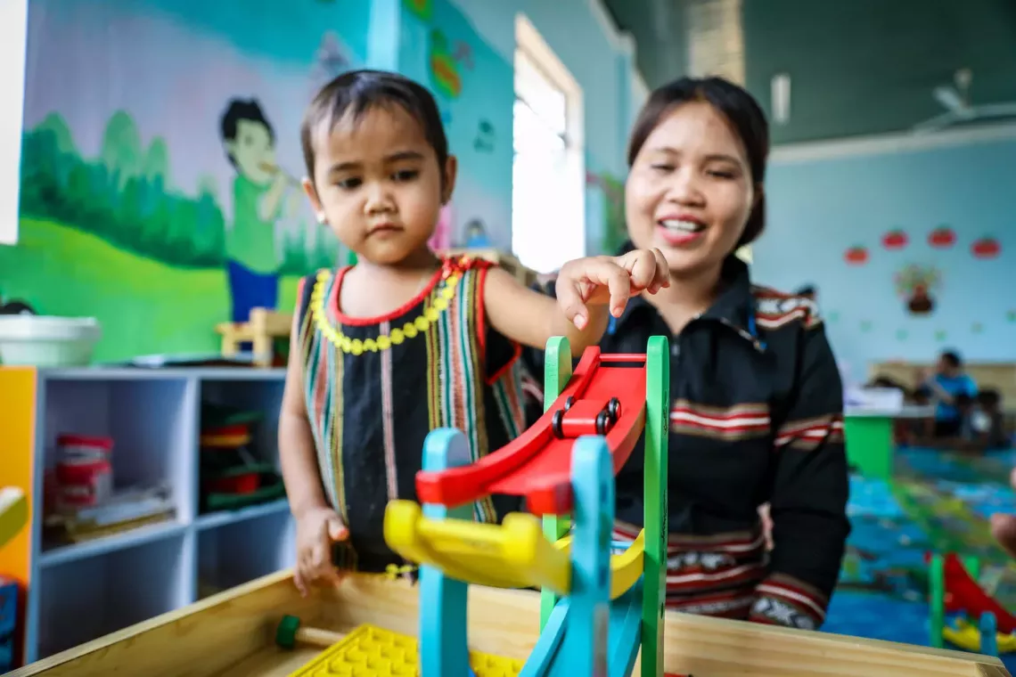 On 9 April 2024, Đơr, 4 years old, Ba Na ethnicity, students of Lo Pang preschool, Mang Yang district, Gia Lai province play with the UNICEF-supported toy set, under the guidance of teacher N&aacute;ch, 31 years old, Ba Na ethnicity in the school&rsquo;s community-based library.