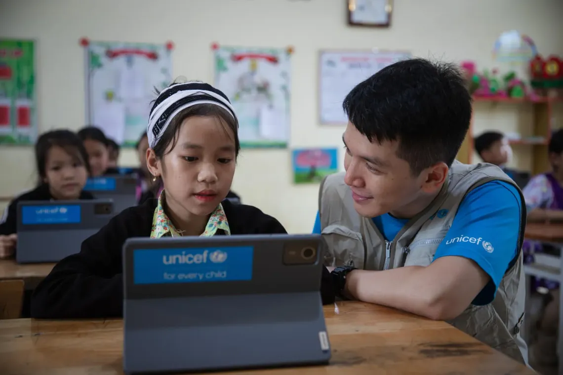 9-year-old Dang Thu Huong, from the Dao ethnic minority, shares her excitement with a UNICEF Education Officer after using the tablet in class. She was amazed to see how AI could help her solve math problems.