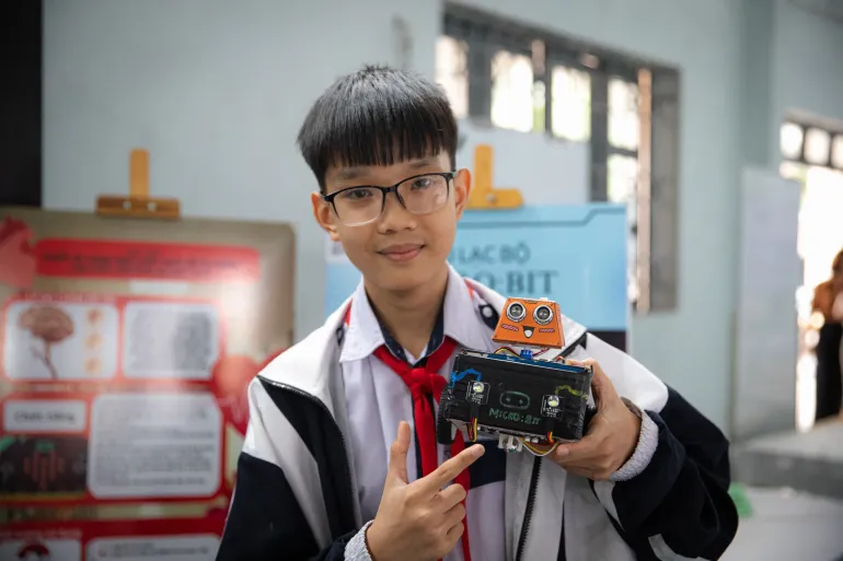 Một bạn học sinh nam cầm robot do m&igrave;nh thiết kế trong cuộc thi Tinkering with Tech