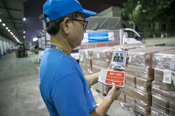 UNICEF staff and representatives from the National Institute of Nutrition (NIN) are loading emergency supplies of Ready-to-Use Therapeutic Food (RUTF) on trucks in Hanoi