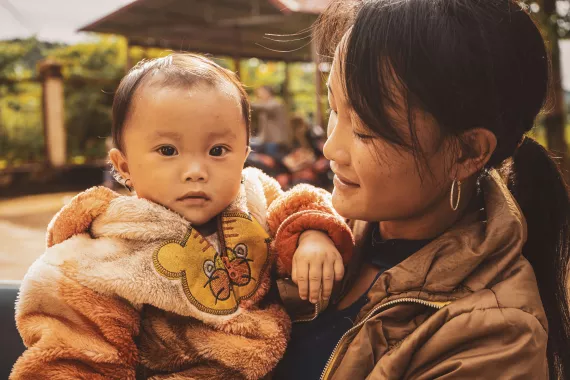 B&eacute; Hạng Thị Y&ecirc;u, trong v&ograve;ng tay y&ecirc;u dấu của mẹ Gi&agrave;y Thị D&uacute;a, người đ&atilde; đồng h&agrave;nh kh&ocirc;ng biết mệt mỏi c&ugrave;ng con tr&ecirc;n chặng đường phục hồi sức khỏe sau khi con chị bị suy dinh dưỡng cấp t&iacute;nh nặng. 