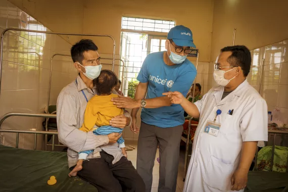 Từ tr&aacute;i sang phải, V&agrave;ng A Dủa bế b&eacute; V&agrave;ng Thị M&aacute;y, &Ocirc;ng Nguyễn Đ&igrave;nh Quang, chuy&ecirc;n gia dinh dưỡng UNICEF trao đổi c&ugrave;ng b&aacute;c sĩ Ly A Nụ, Trưởng khoa Nhi, về trường hợp suy dinh dưỡng nặng cấp t&iacute;nh của b&eacute; M&aacute;y tại Bệnh viện Đa khoa huyện Điện Bi&ecirc;n Đ&ocirc;ng, tỉnh Điện Bi&ecirc;n.