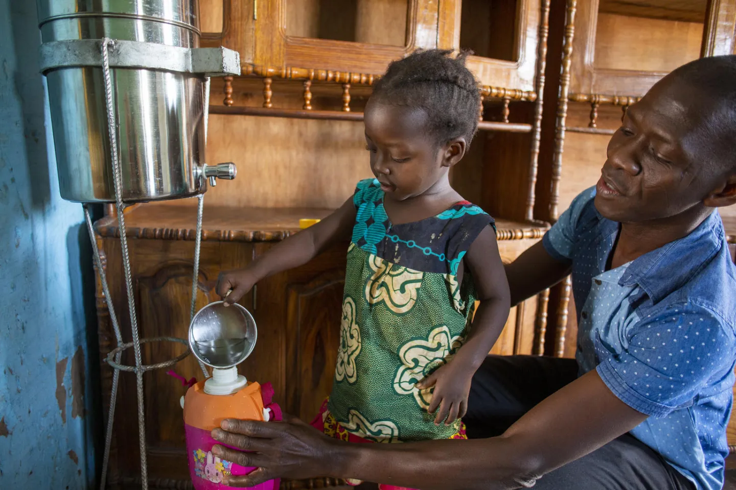 Malado Djalo show his daughter Aua Djalo how to use a water purifier that the family received from Unicef in Bafata, Guinea Bissau