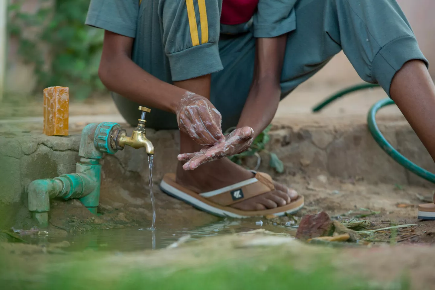 13-year-old Azhari, washes his hands with soap that he received from the mass health, nutrition and WASH campaign in Atbara, River Nile state where he and his family sought refuge after fleeing the war in Khartoum.