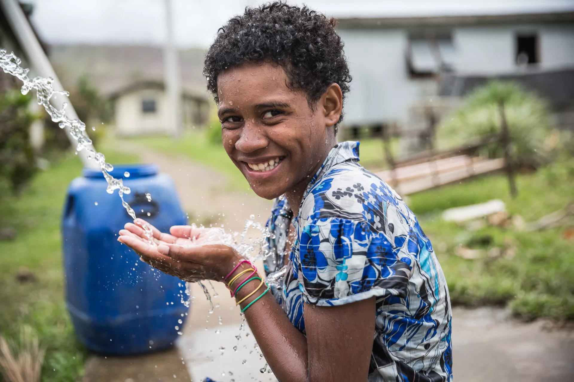 Ana, 11, bathing using tap water in Lawaki village, Tailevu Province.